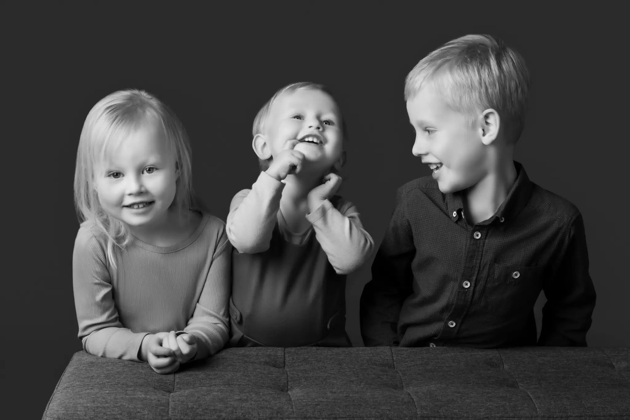 A black-and-white BP Portraits portrait of three siblings